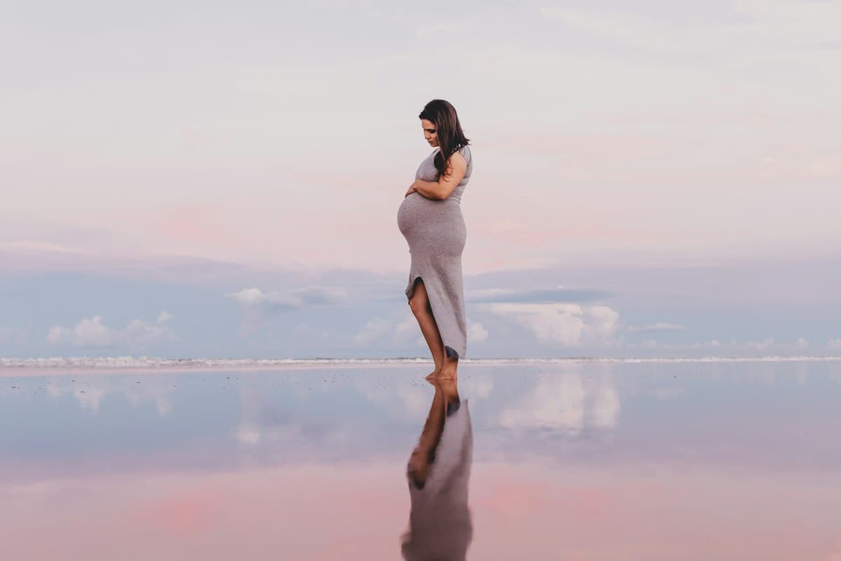Femme enceinte sereine au bord de l'eau, préparation à l'accouchement