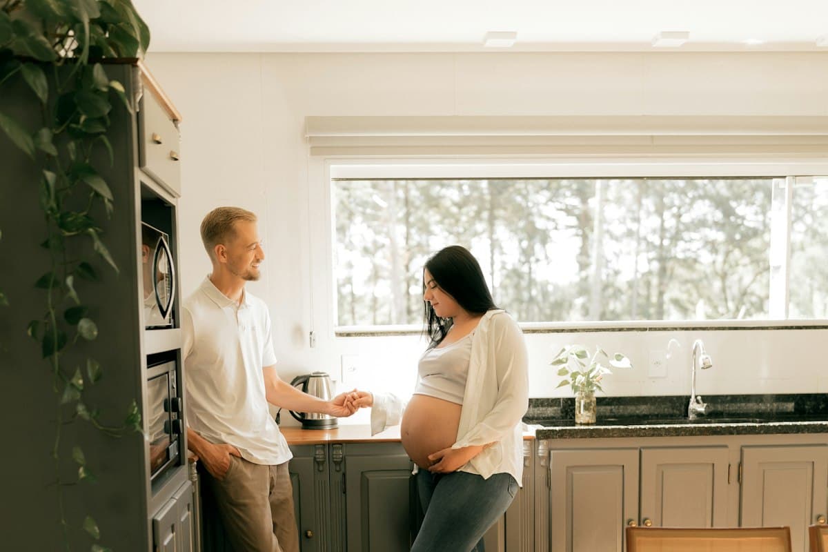 Femme enceinte souriante dans sa cuisine, sereine face au diabète gestationnel
