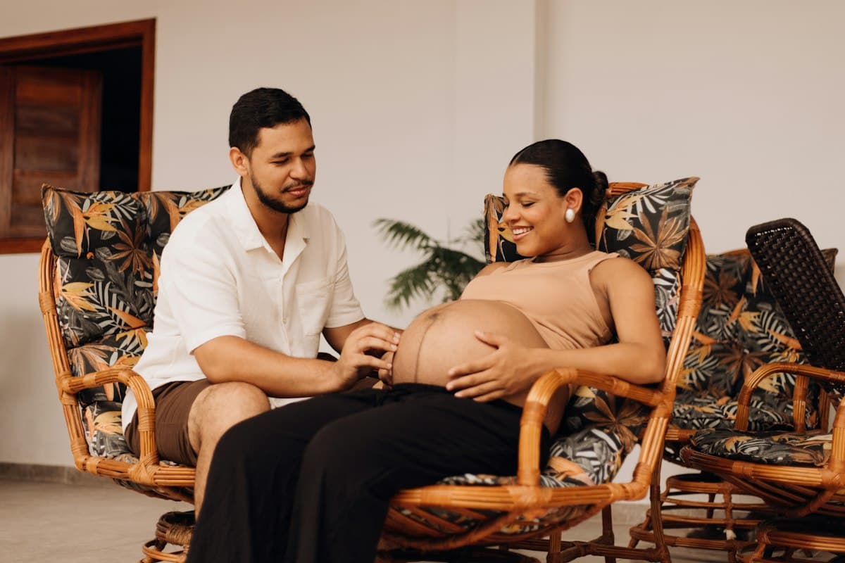 Futurs parents souriants à la maison avant l'entretien prénatal précoce