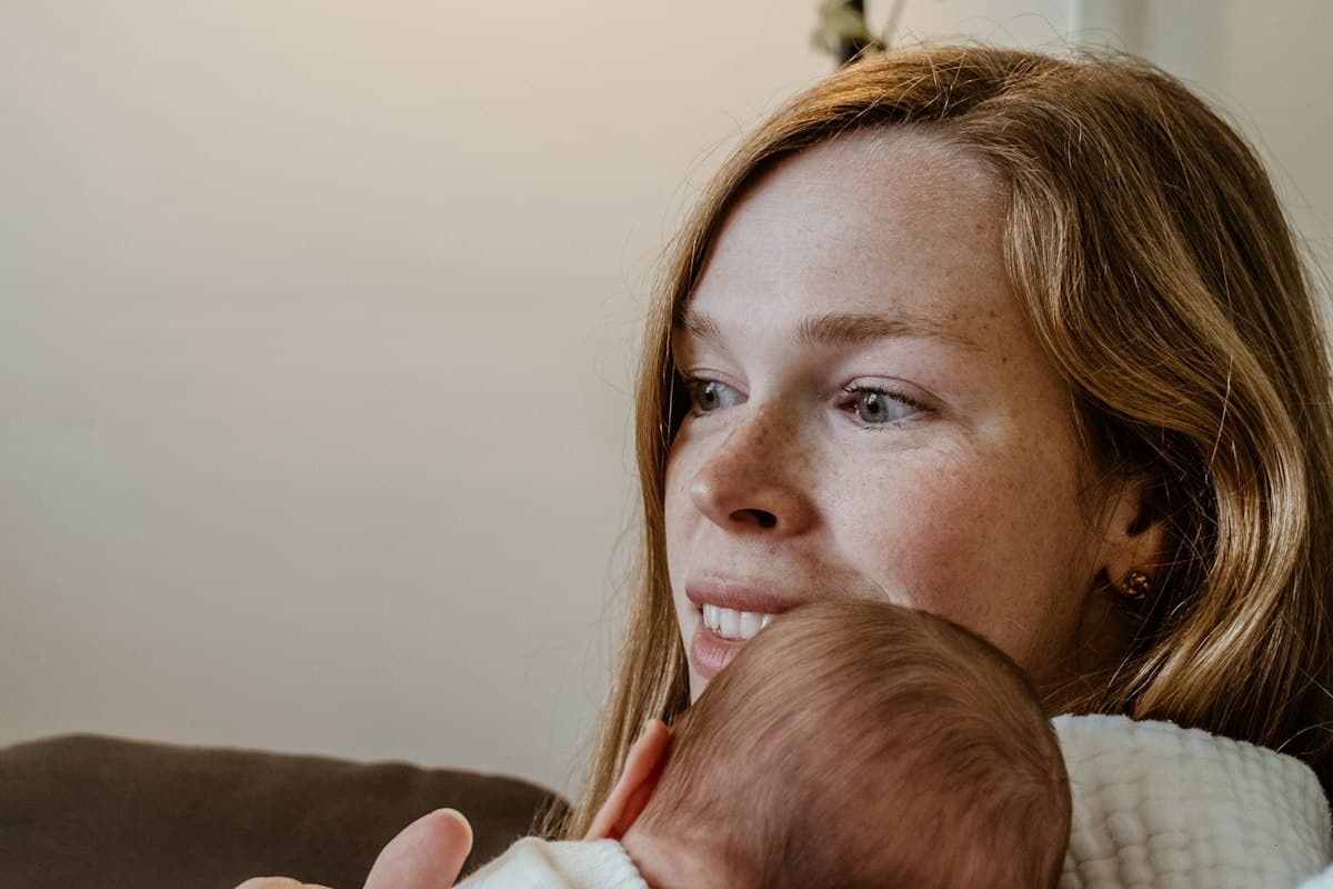 Jeune mère pensive serrant son nouveau-né contre elle, phobie d'impulsion post-partum
