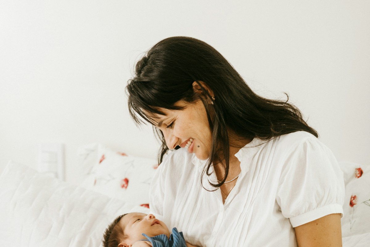 Mère souriante avec son bébé, sérénité retrouvée après un accouchement mal vécu