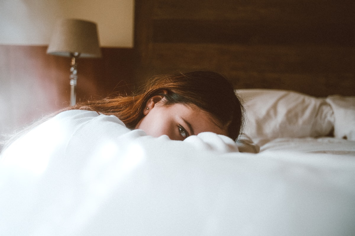 Femme vivant une angoisse au reveil, allongee dans son lit le matin