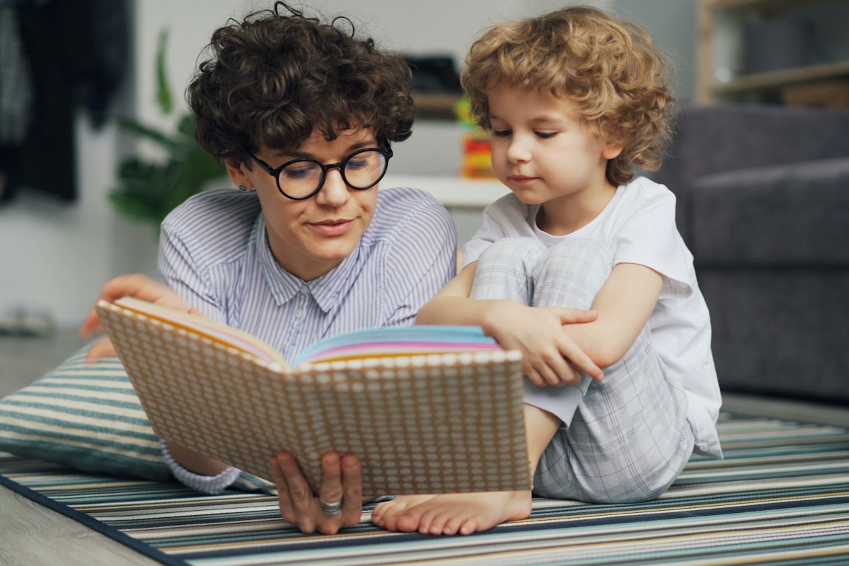 Mère lisant une histoire à son enfant, rituel du coucher contre l'angoisse de séparation