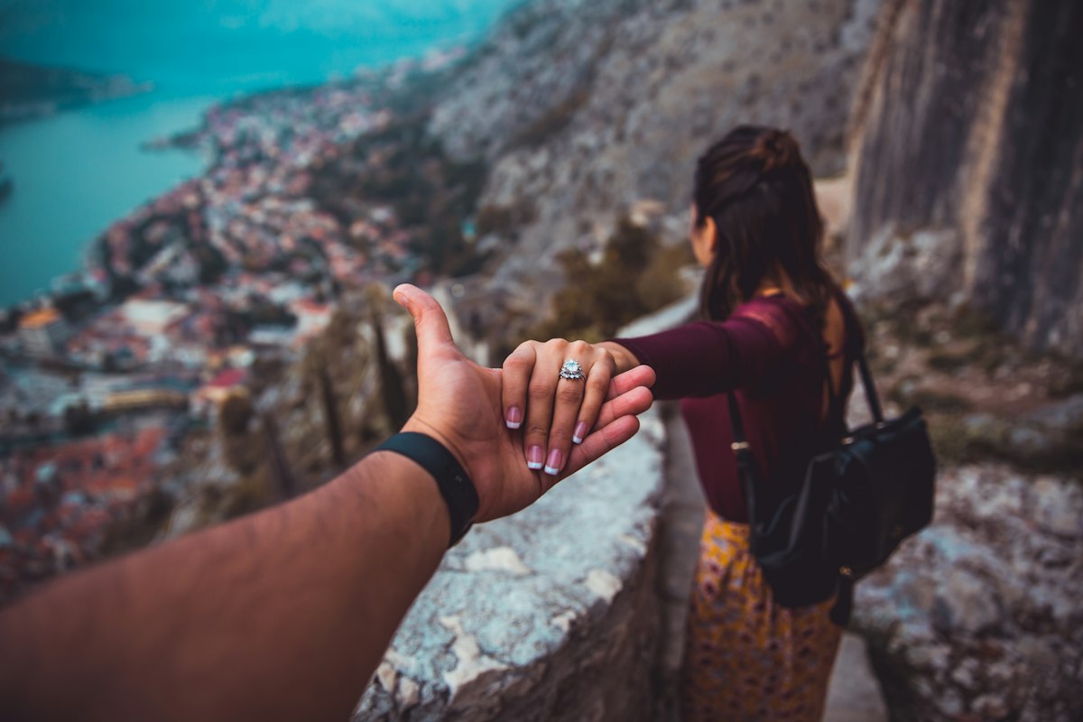 Couple se tenant la main en voyage, apaiser l'anxiété relationnelle