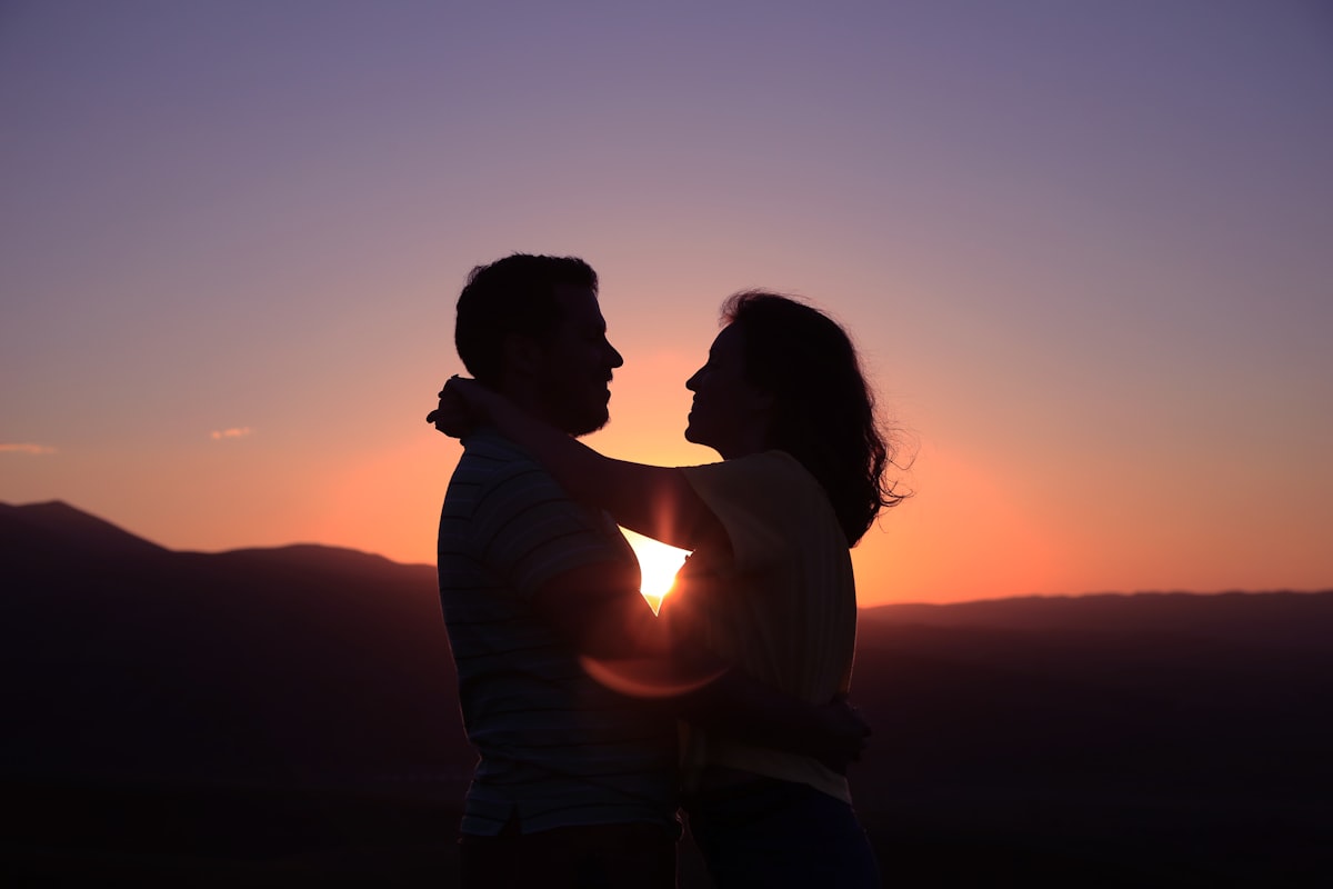 Couple enlacé au coucher du soleil, complicité et intimité retrouvées