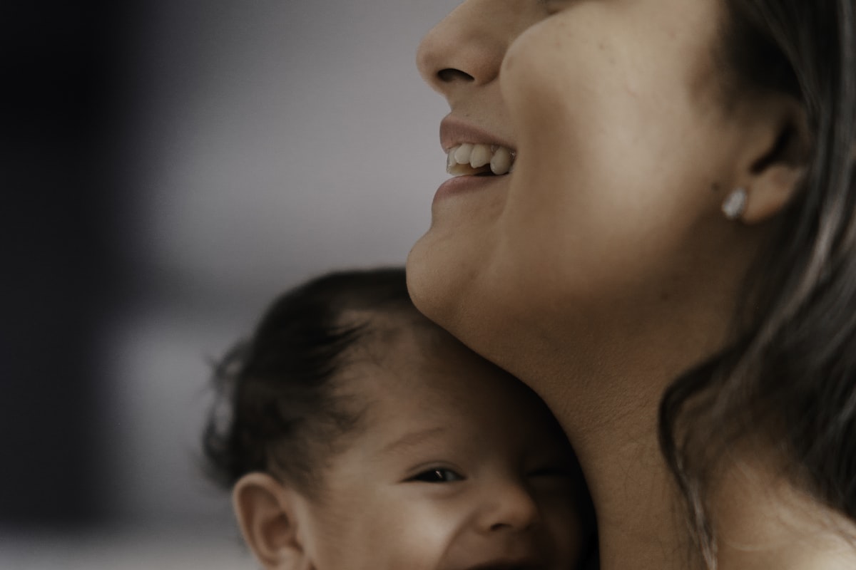 Maman souriante et son bébé apaisé, ostéopathie et sommeil de bébé au quotidien