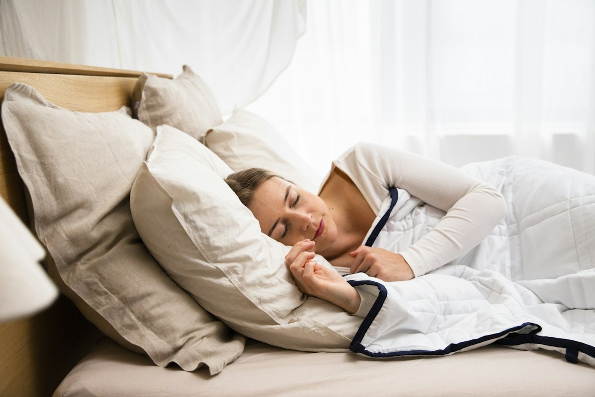 Femme endormie sur le côté, poignets repliés : une position qui favorise les fourmillements des mains la nuit pendant la grossesse