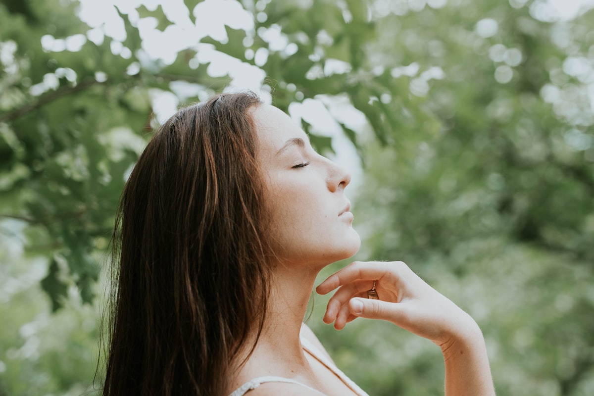 Femme apaisée respirant au frais en pleine nature pendant l'été