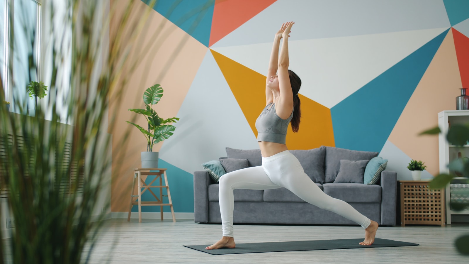 Femme pratiquant un yoga doux à domicile pour reprendre une activité physique en douceur