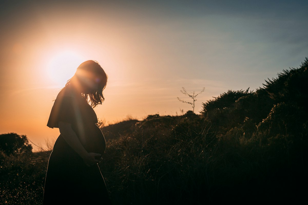 Femme enceinte au coucher du soleil, après une mesure de col court