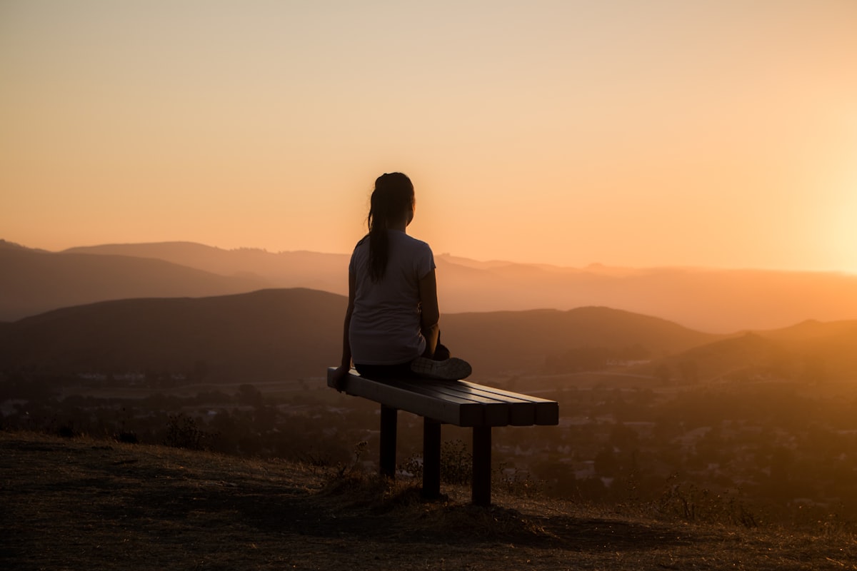 Femme apaisée au coucher du soleil, traversant l'été en sérénité