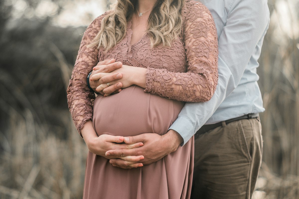 Couple enlaçant le ventre de grossesse, préparation à la naissance à deux