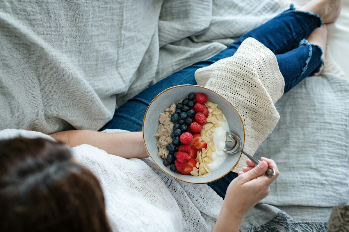 Femme enceinte savourant un bol de flocons d'avoine et fruits rouges, alimentation et diabète gestationnel