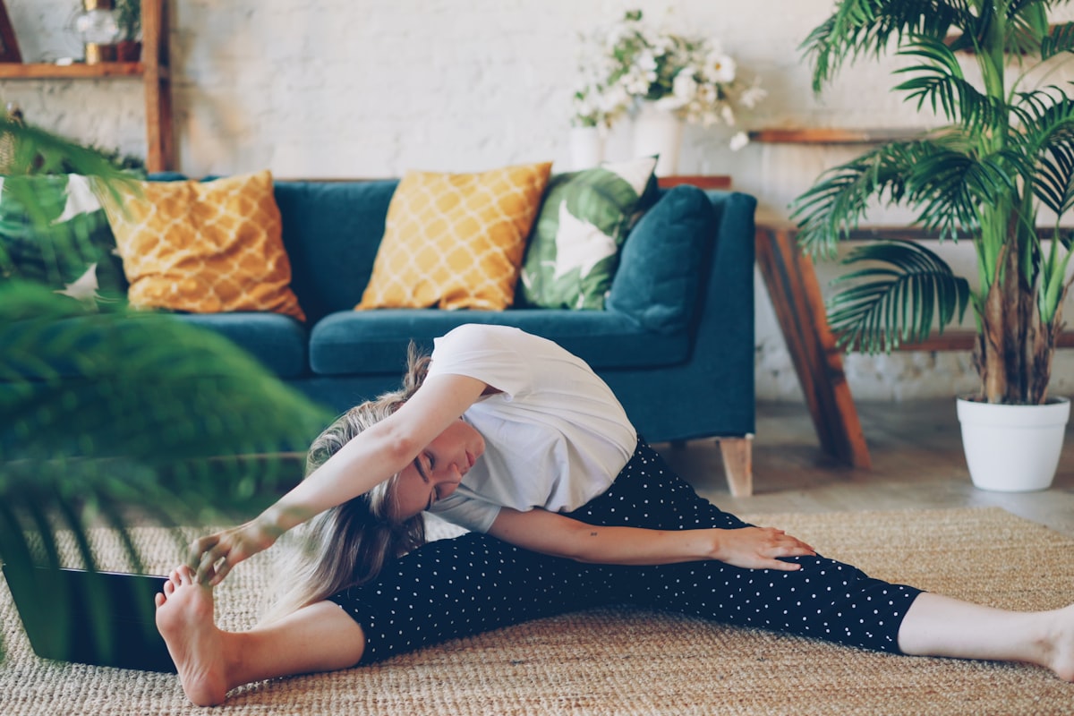 Femme pratiquant des étirements chez elle pour soulager un dos bloqué