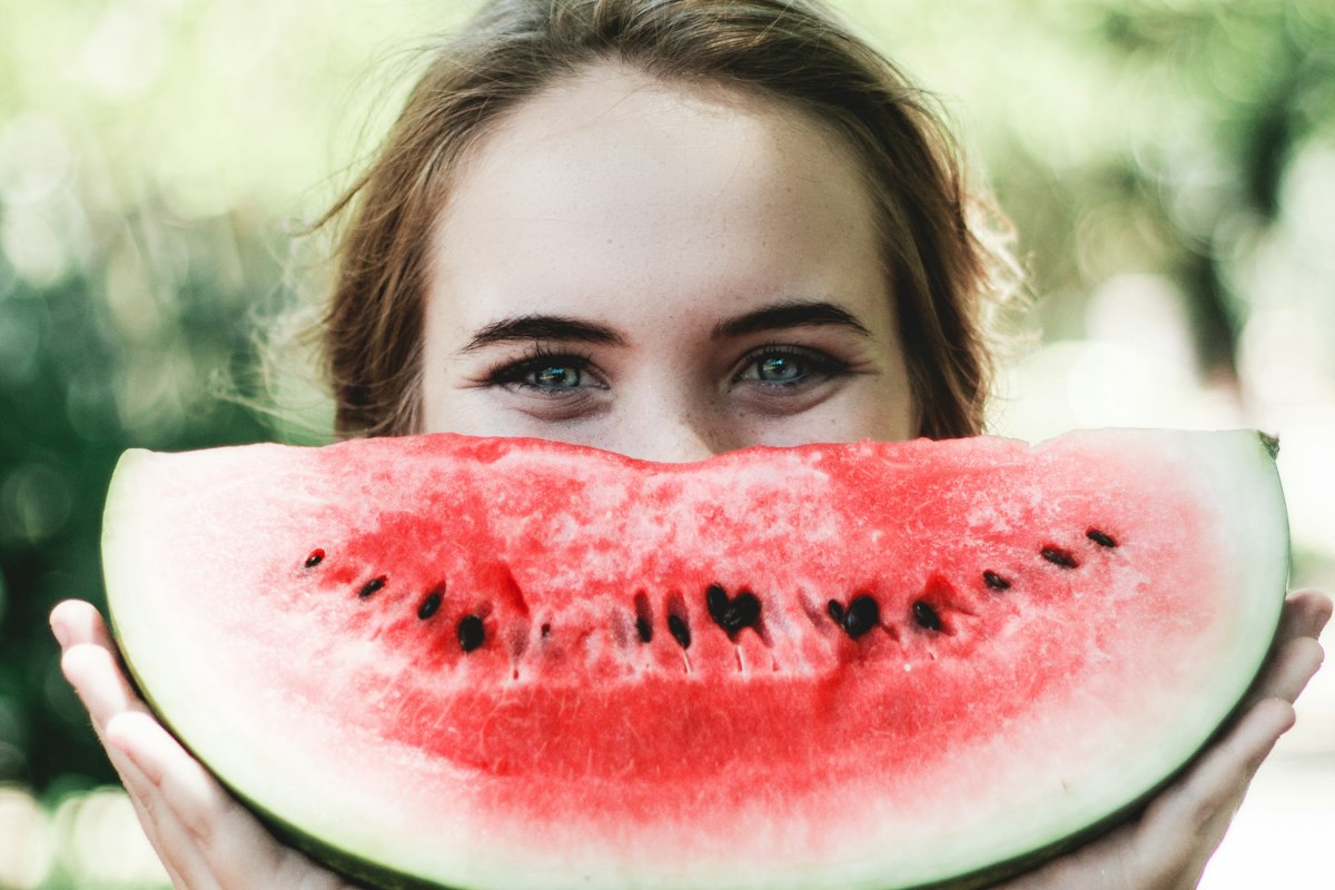 Femme souriante avec une pastèque, alimentation et échographie de croissance