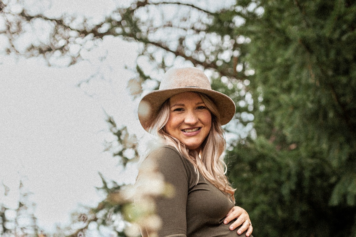 Femme enceinte souriante en extérieur après son échographie morphologique du 2e trimestre