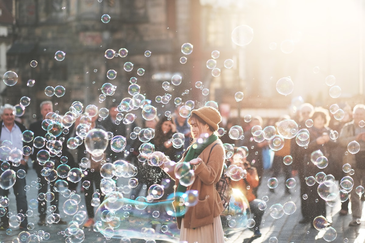 Jeune femme souriante entourée de bulles de savon, image d'espoir face à l'état de stress post-traumatique
