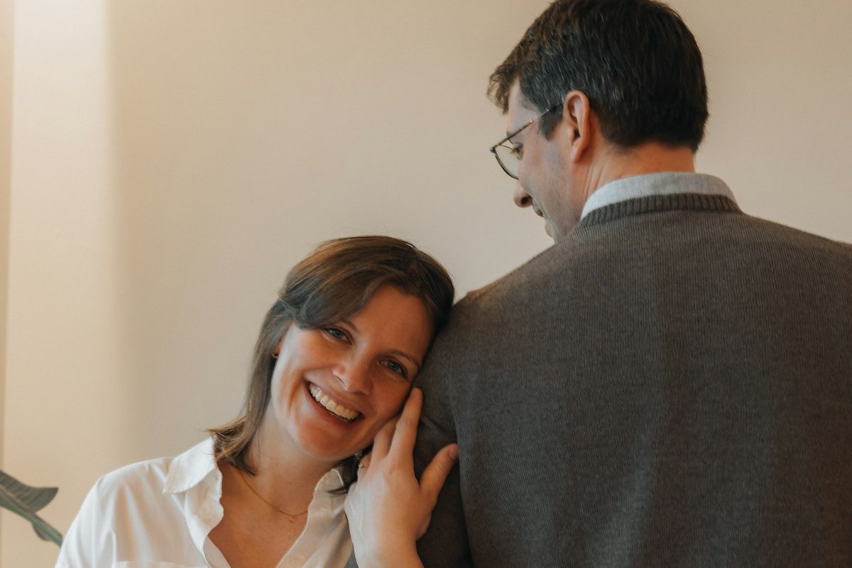 Couple souriant à la maison pendant le suivi d'une échographie de grossesse gémellaire