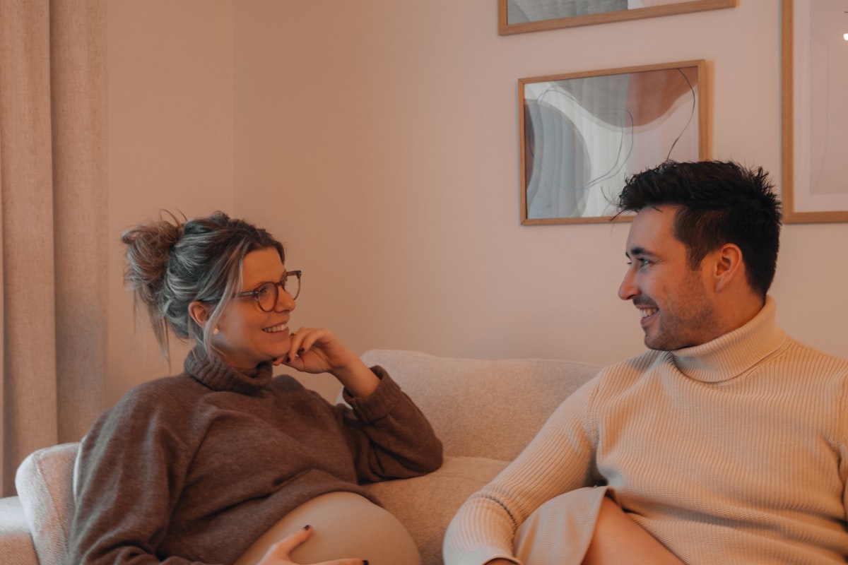 Couple enceinte échangeant à la maison entre deux échographies de la grossesse
