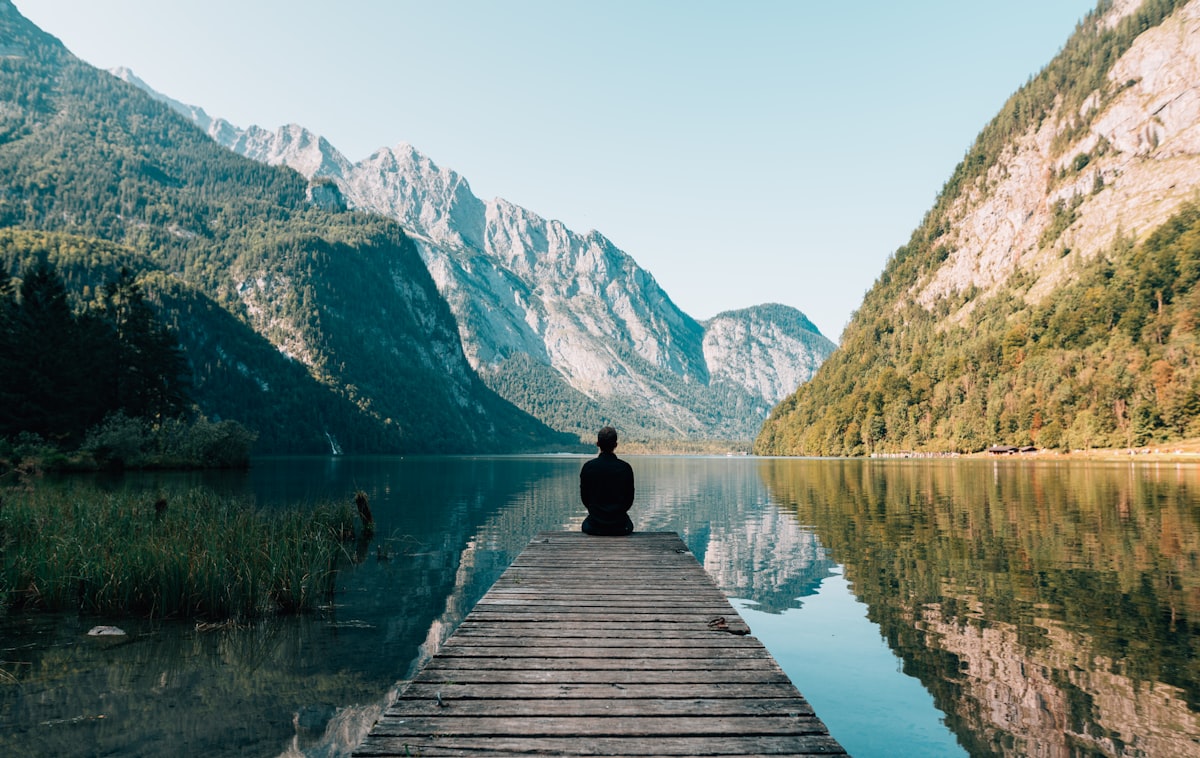 Femme sereine au bord d'un lac, illustrant la prévention du mal de dos au quotidien