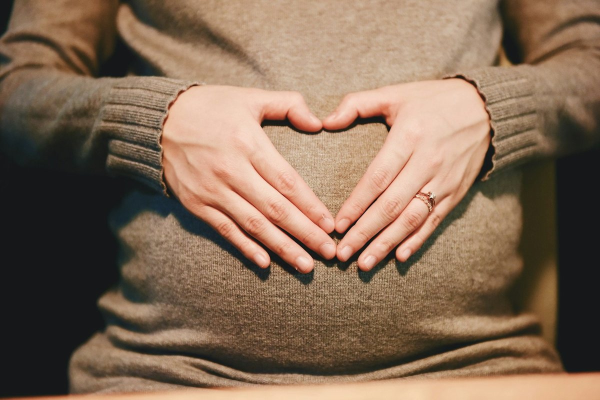 Future maman mains sur le ventre, pertes blanches grossesse normales