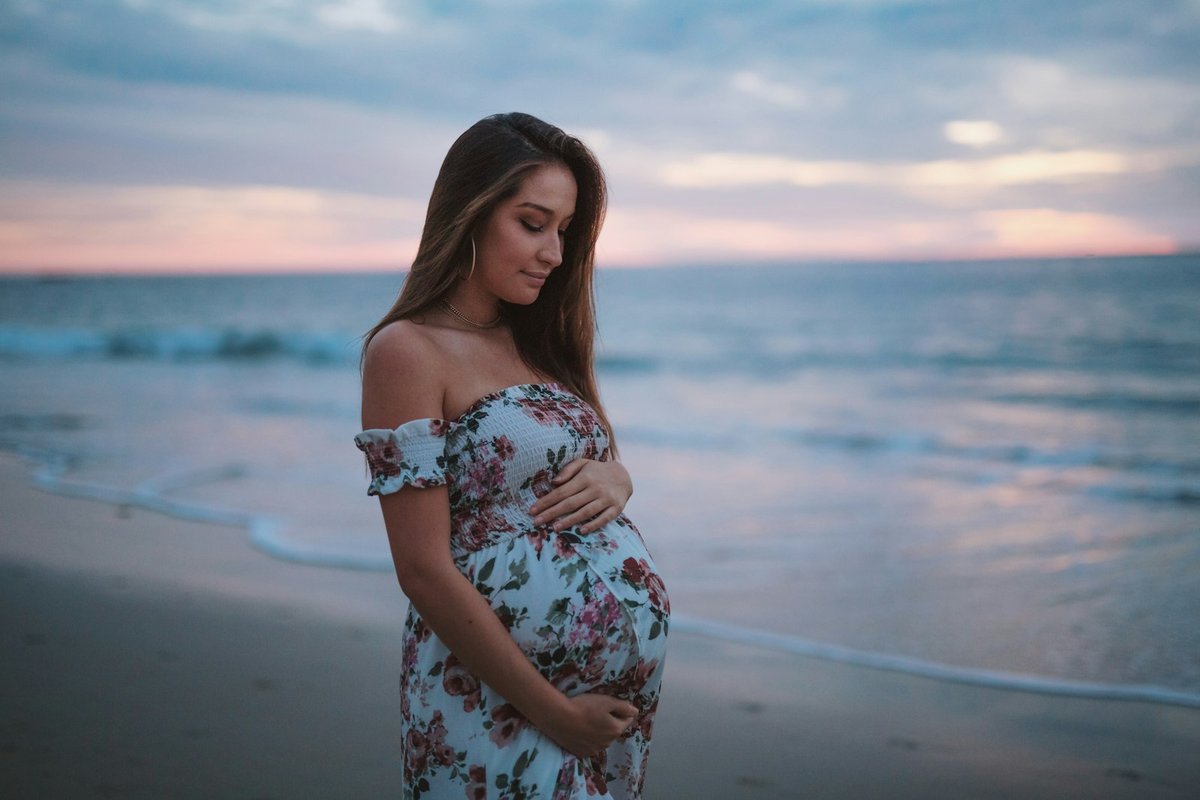 Femme enceinte apaisée en extérieur, bien-être et perte blanche grossesse