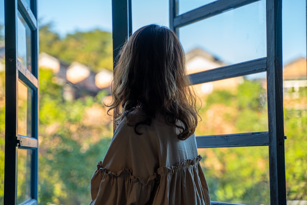 Enfant anxieux à la fenêtre le matin, phobie scolaire