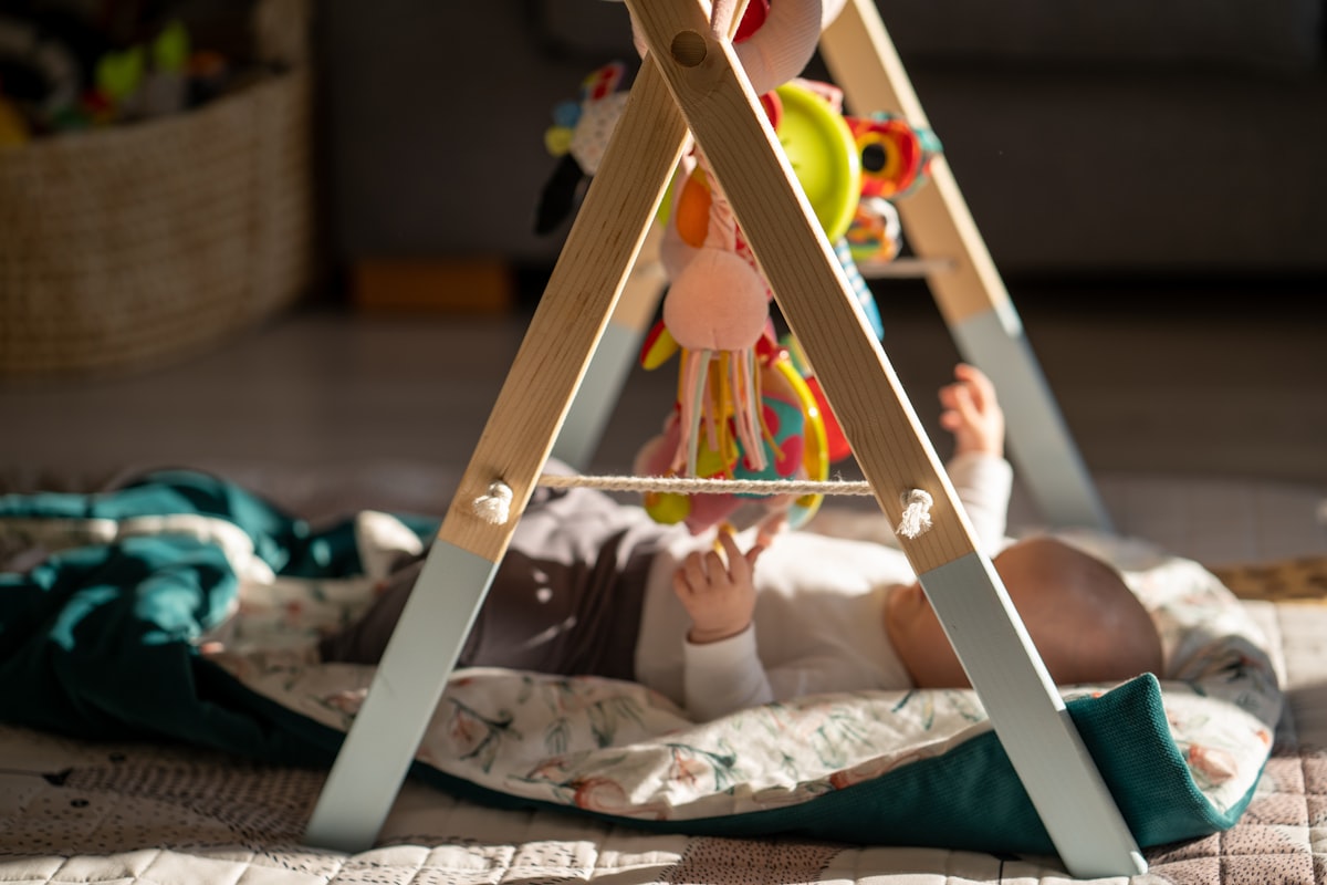 Bébé jouant au sol sur un tapis d'éveil pour prévenir la plagiocéphalie