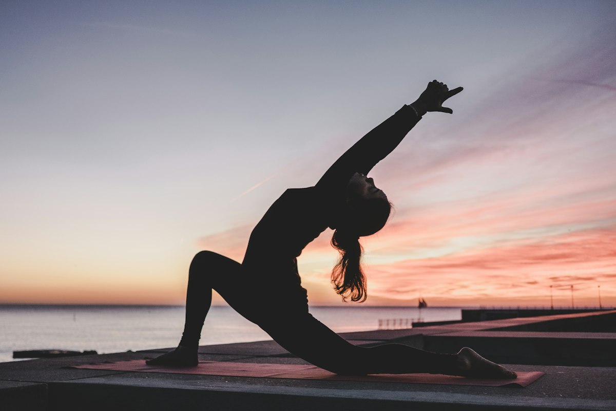 Femme qui s'étire au coucher du soleil, relâcher le périnée contre les rapports douloureux