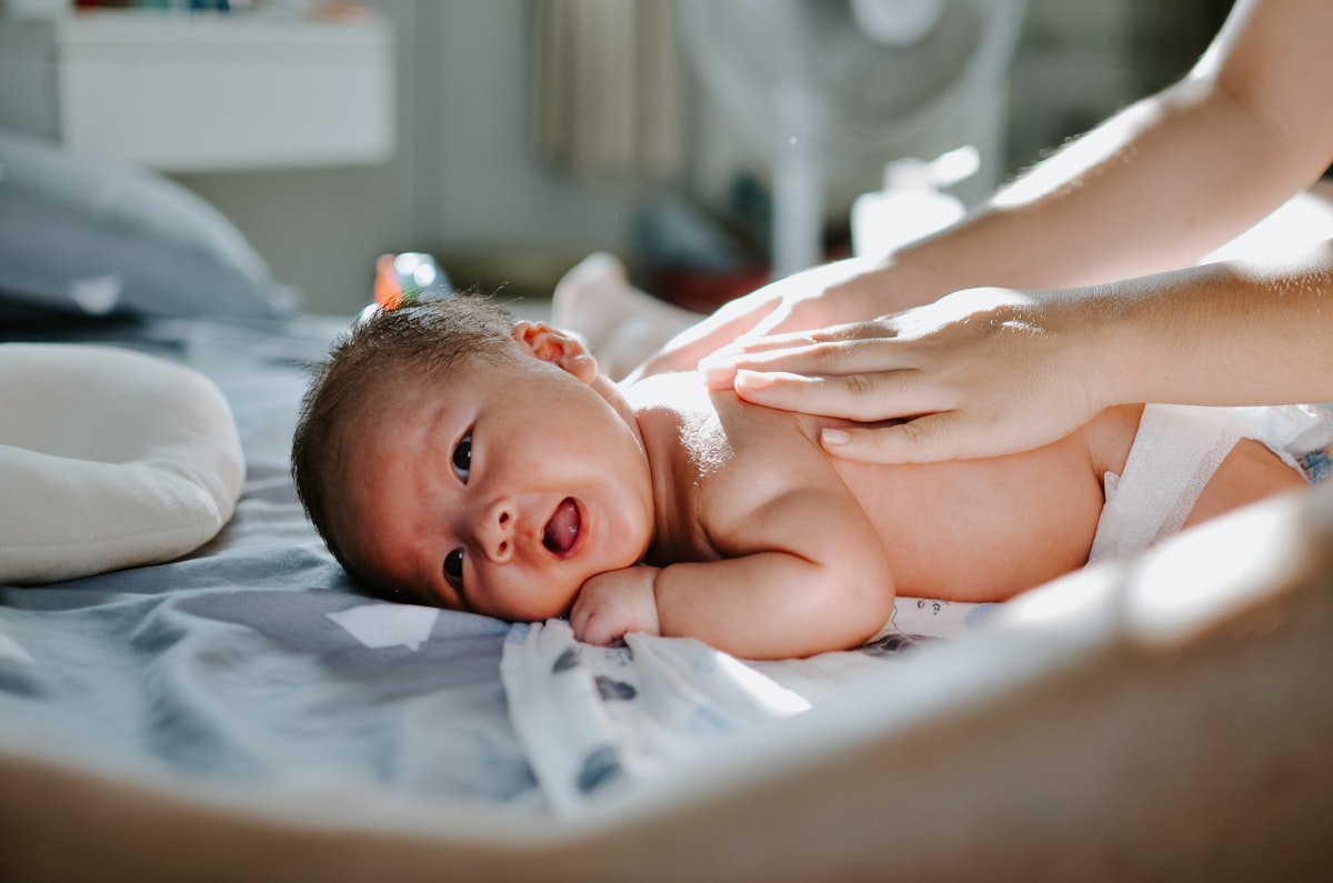 Massage doux du ventre d'un nourrisson pour soulager coliques et reflux
