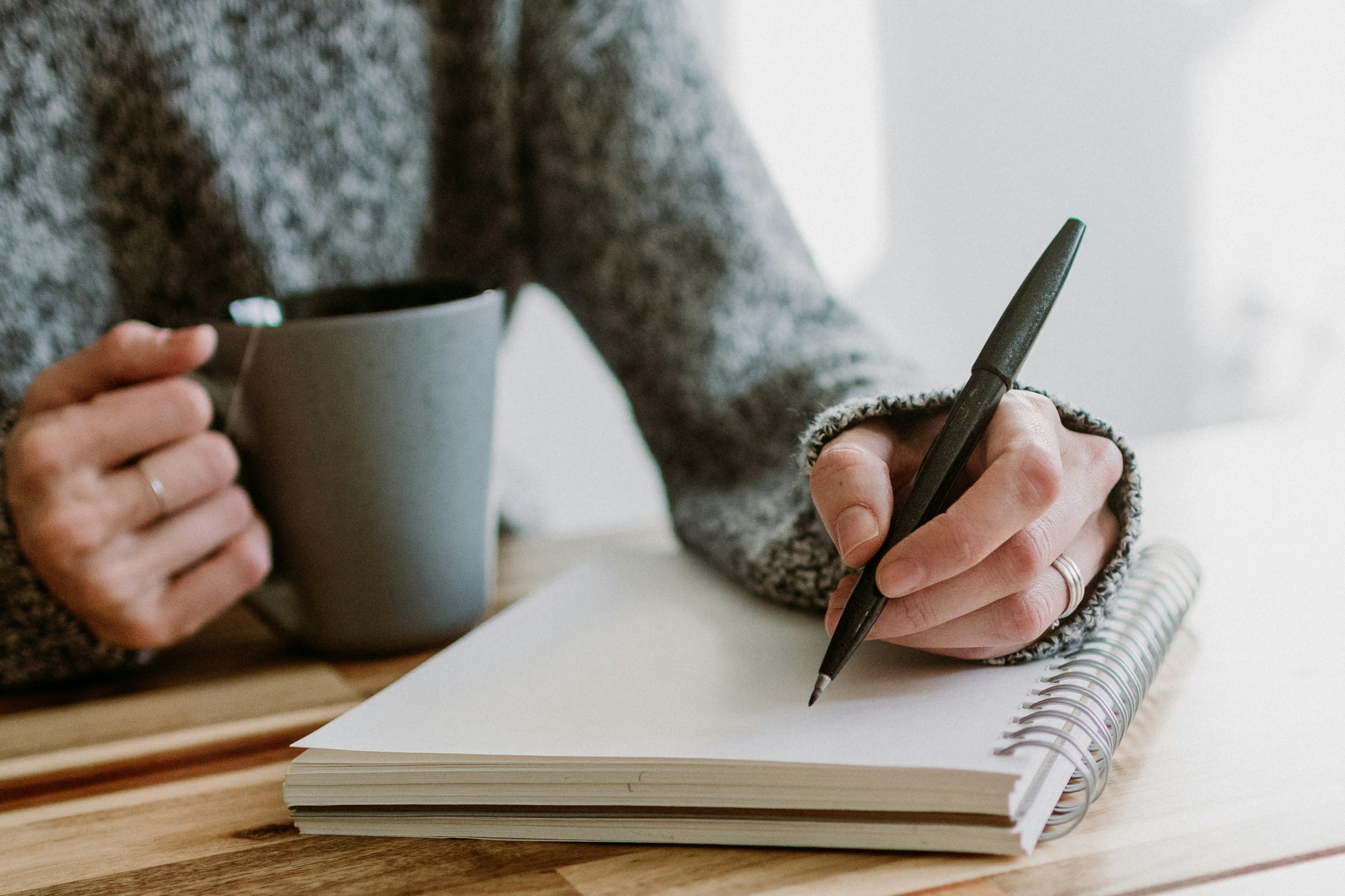Femme tenant un carnet et une tasse, pause bien-être face au burn-out