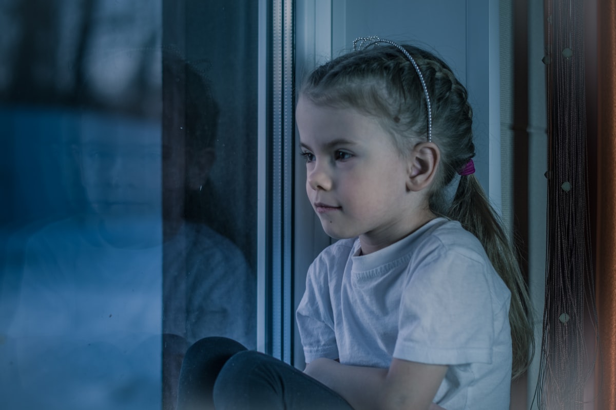 Enfant pensif a la fenetre, maux de ventre et anxiete de l'enfant