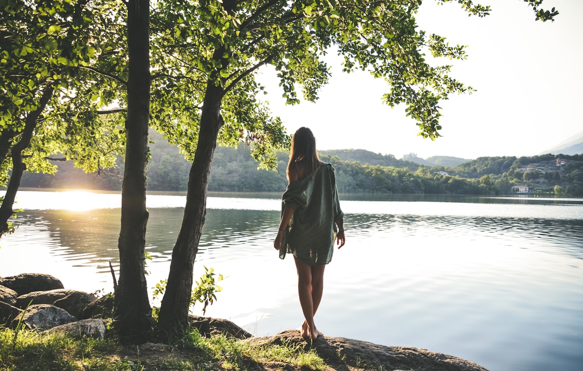 Femme apaisée en pleine nature au bord d'un lac, mieux vivre le SOPK au quotidien