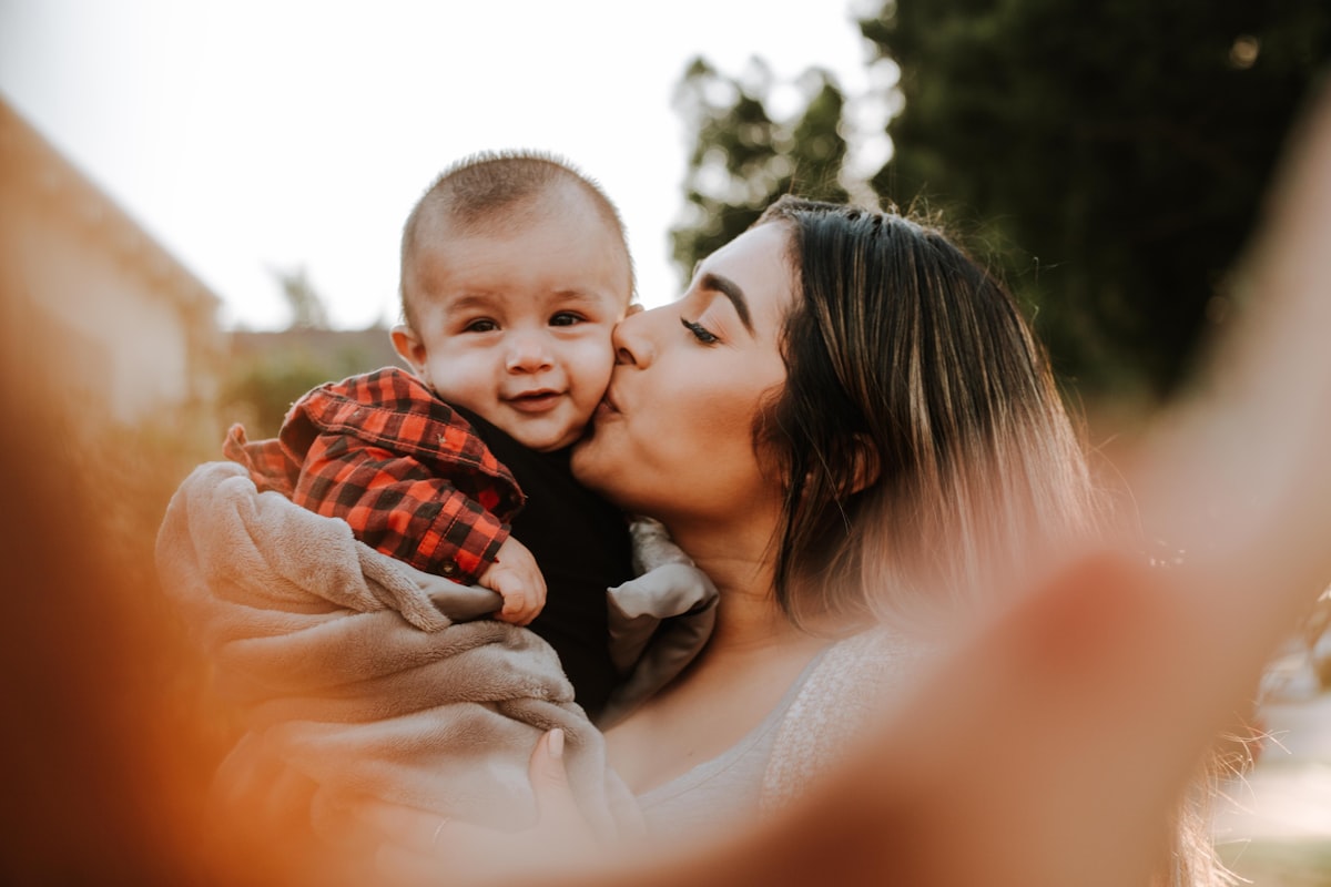 Mère embrassant son bébé au cou souple après rééducation du torticolis congénital